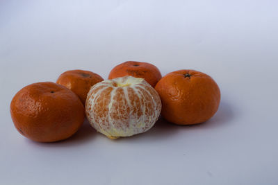 Close-up of orange fruits on white table
