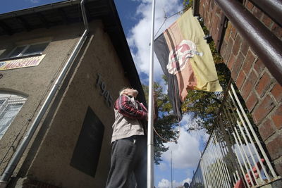 Low angle view of woman standing by building