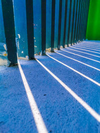 Close-up of metal fence against blue wall