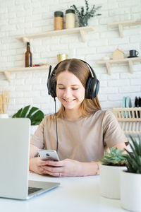 Smiling young woman using smart phone