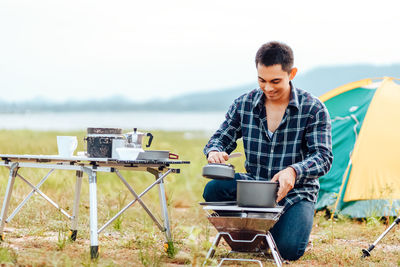 Young man using mobile phone while sitting outdoors