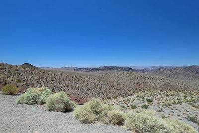 Scenic view of desert against clear blue sky