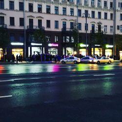 Cars on road by buildings in city