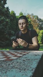 Portrait of young man sitting in park