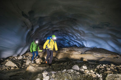 Couple exploring ice cave near vancouver, canada.