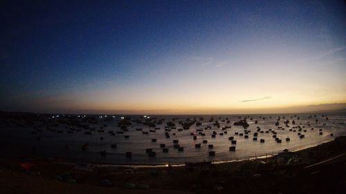 Flock of birds on beach against sky