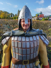 Portrait of man wearing armor against sky