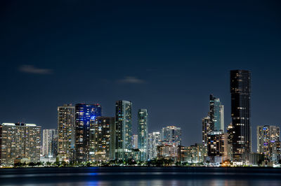 Illuminated buildings against sky at night