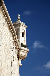 Low angle view of bell tower against blue sky