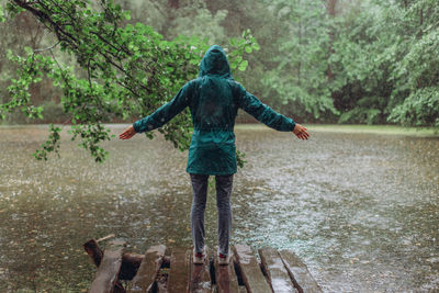 Full length rear view of man standing in rain