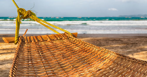 Close-up of hammock at beach against sky
