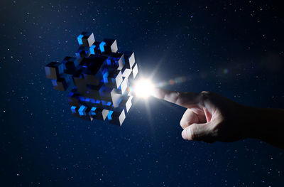 Digital composite image of man touching cube shaped box in space
