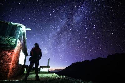 Low angle view of woman standing against star field at night