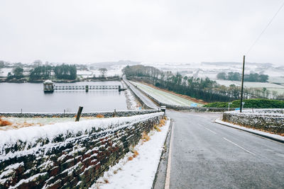 Road in city against sky during winter