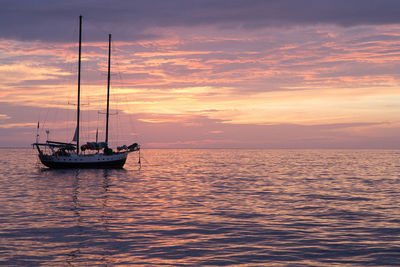 Boat sailing in sea at sunset