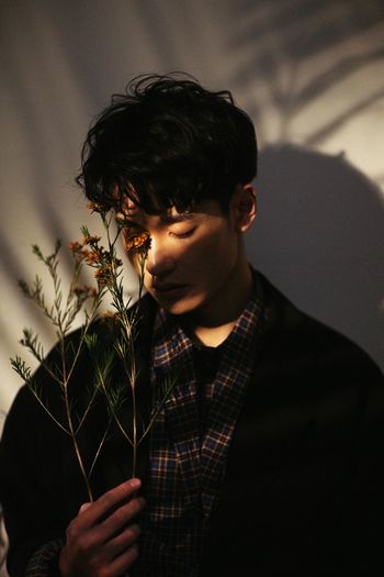 PORTRAIT OF YOUNG MAN WITH PLANT