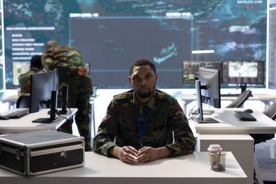 Rear view of man using mobile phone in cafe