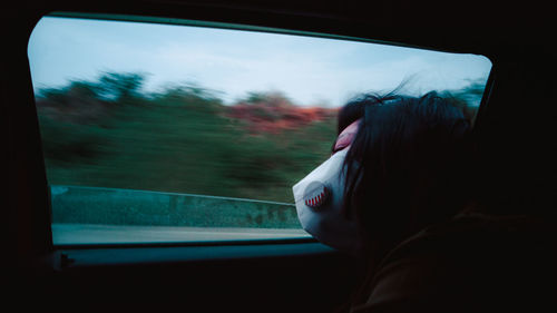 Man looking through window in car