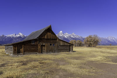 Built structure on field against clear blue sky