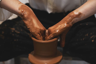 Midsection of man making pot