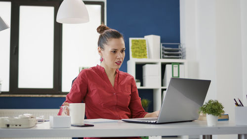 Businesswoman using laptop at desk