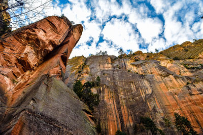 Low angle view of rock formations against cloudy sky