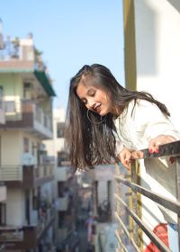 Woman smiling while standing on balcony