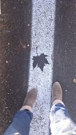 Low section of man standing on road