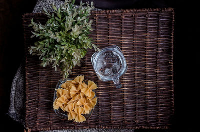 Directly above shot of farfalle pasta and drinking water on wicker mat