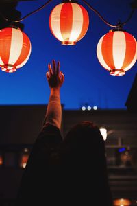 Low angle view of illuminated lantern against sky at night