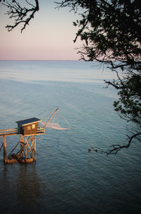 Scenic view of sea and fishing hut against sky