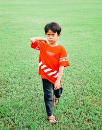 Portrait of boy playing with ball on field