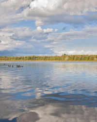 Scenic view of calm lake against cloudy sky