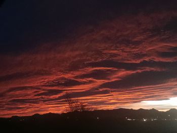 Scenic view of dramatic sky over silhouette landscape