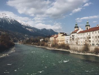 Houses on mountain against cloudy sky