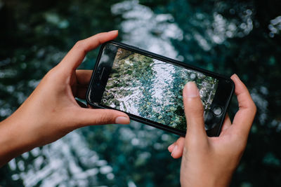 Cropped image of hand holding mobile phone