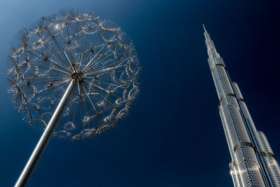 Low angle view of ferris wheel against blue sky