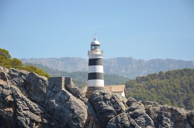 Lighthouse on mountain against clear blue sky