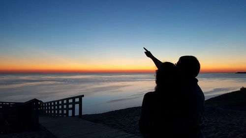 Silhouette of couple at beach during sunset