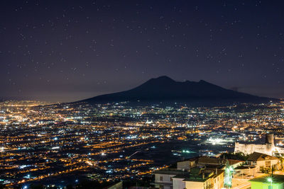 Aerial view of illuminated cityscape against sky at night