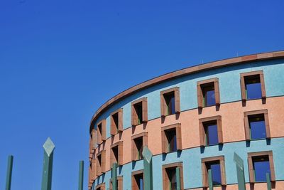 Low angle view of modern building against clear blue sky