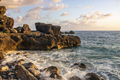 Rocks on sea shore against sky