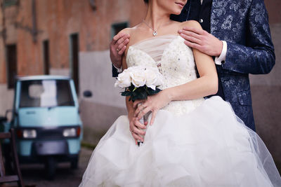 Midsection of woman holding bouquet