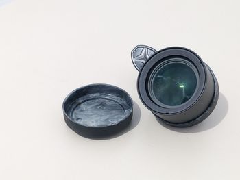 High angle view of camera on glass against white background