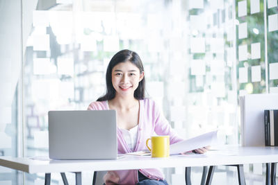 Portrait of smiling young woman using mobile phone