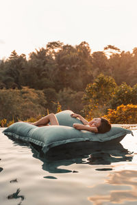 Woman relaxing on pool raft in swimming pool
