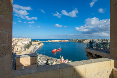 High angle view of buildings by sea against sky