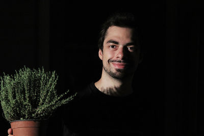 Portrait of smiling man against black background