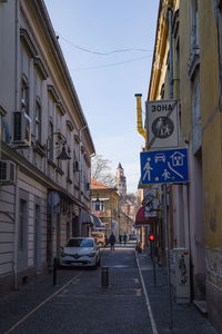 Road amidst buildings in city against sky