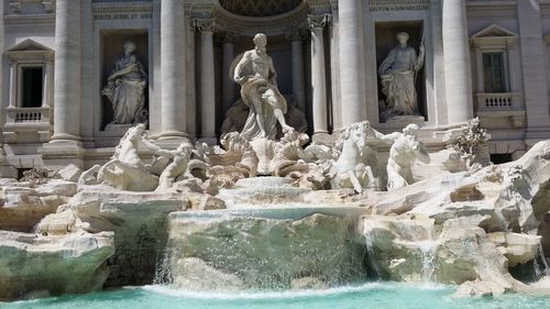 Statue of fountain in front of historical building